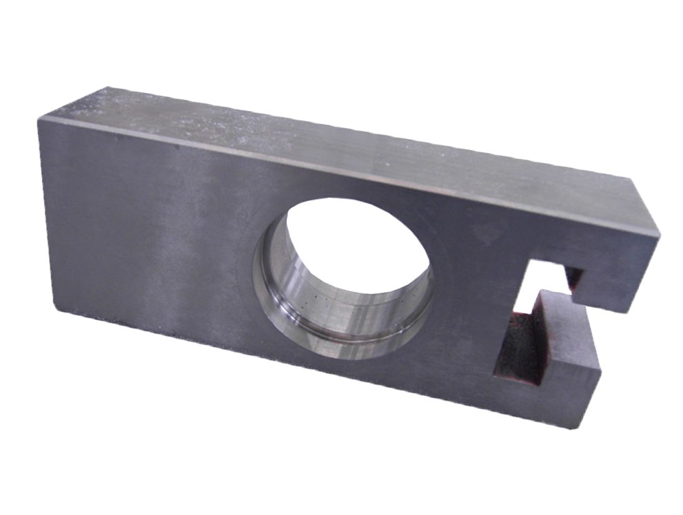 Machined metal block with a large bore and side openings